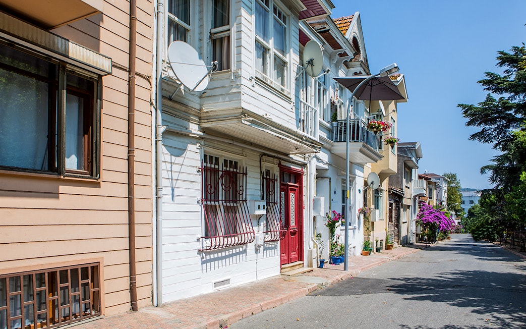 Streetscape of Princess Island with traditional houses and blooming flowers.