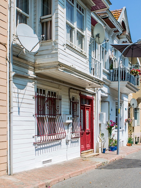 Streetscape of Princess Island with traditional houses and blooming flowers.
