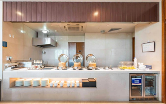Buffet counter at Shanghai Hongqiao International Airport Terminal 1 with serving dishes and plates.