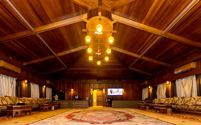 Desert lounge interior with wooden ceiling and traditional seating, part of hot air balloon experience.