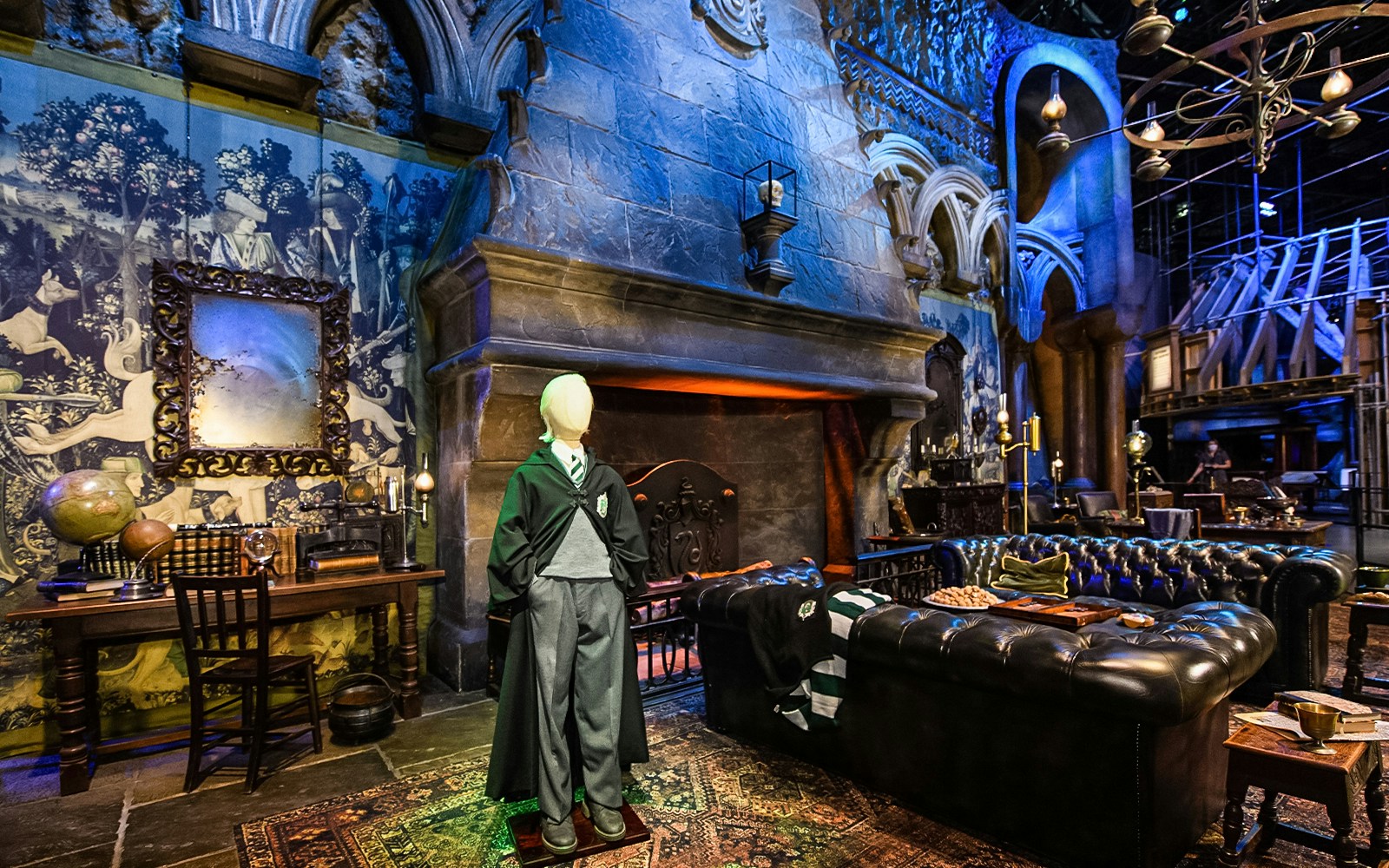 Slytherin common room set at Warner Bros. Studio Tour London, featuring fireplace and decor.