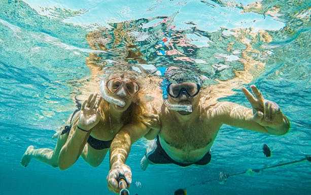 Snorkelers exploring underwater life in the Red Sea during a Sea Scope Submarine trip.