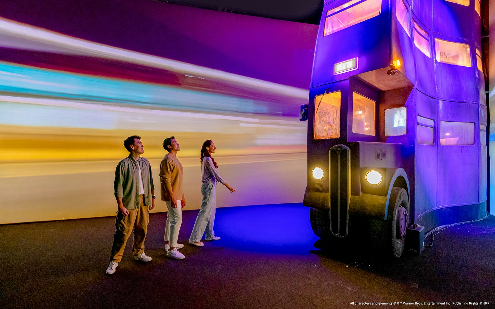 People admiring the Knight Bus at Harry Potter Visions of Magic exhibit.