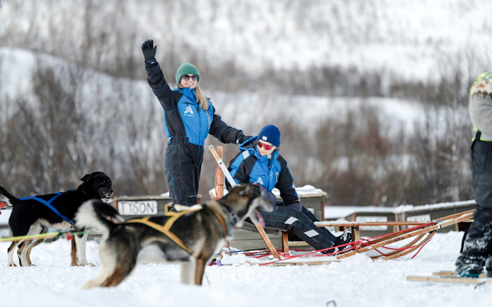 Guests dogsledding and visiting a kennel in snowy Tromso.