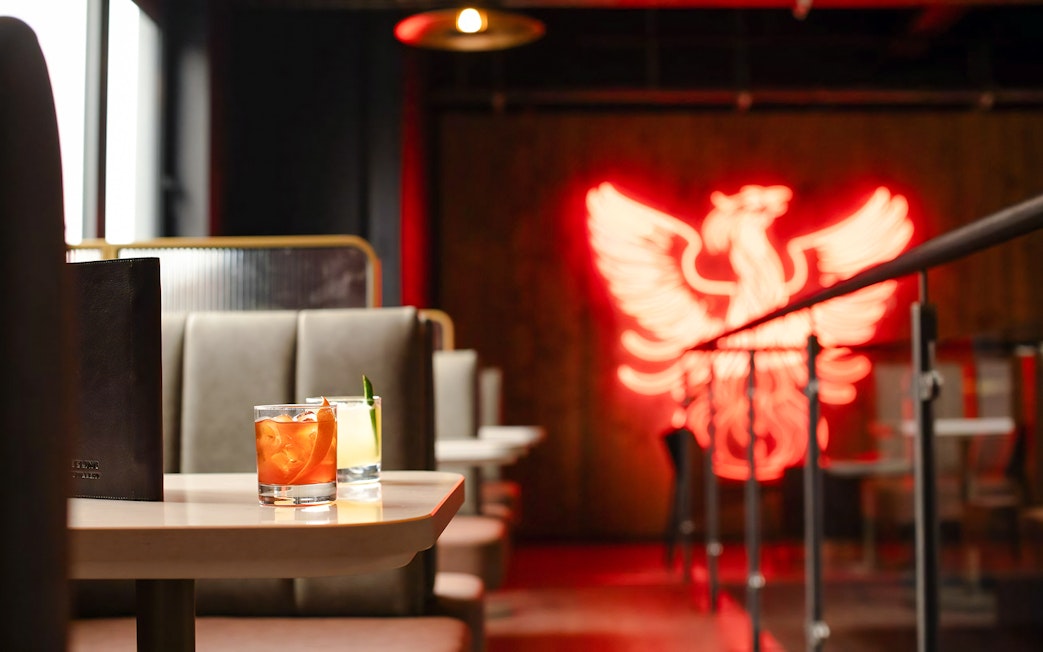 Teeling Whiskey Distillery interior with cocktails and neon phoenix sign.