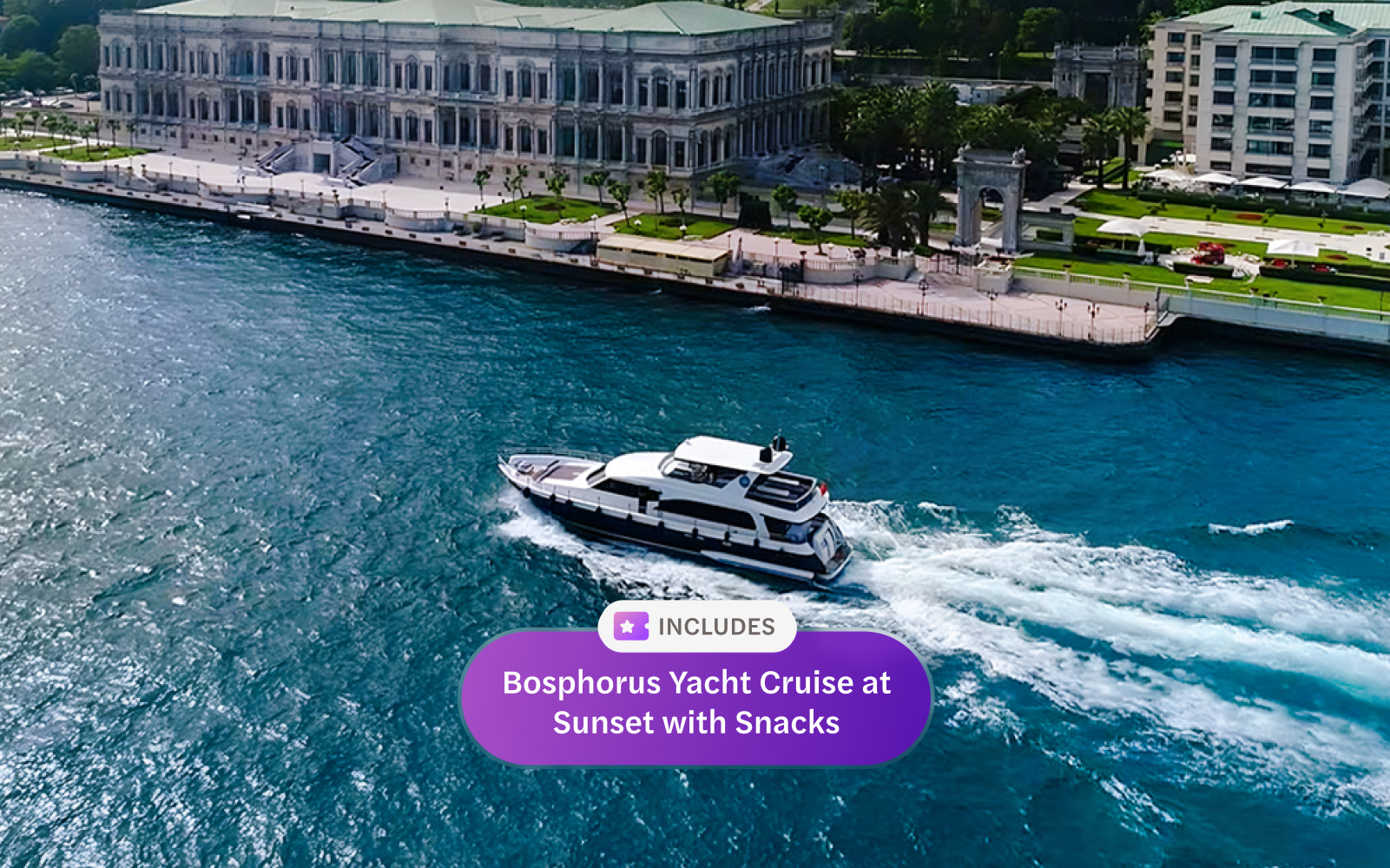 Bosphorus yacht cruising past Dolmabahçe Palace, Istanbul, aerial view.