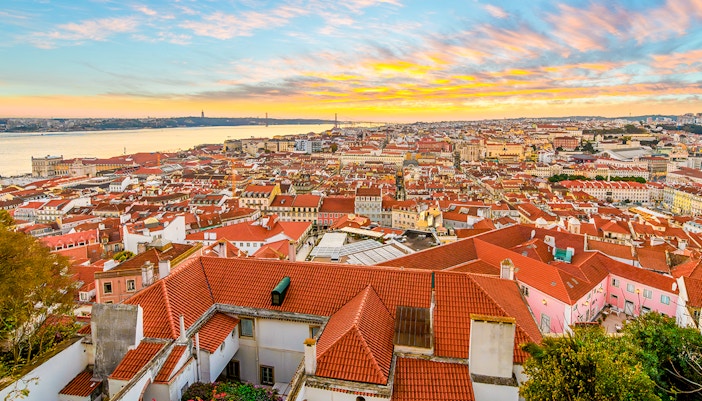 Sunset view from the Alfama district's Castelo de São Jorge overlooking the old town historic center Baixa and Bairro Alto districts of Lisbon, Portugal.