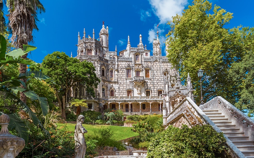 Quinta da Regaleira palace with ornate facade and lush gardens in Sintra, Portugal.