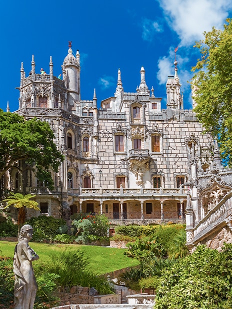 Quinta da Regaleira palace with ornate facade and lush gardens in Sintra, Portugal.