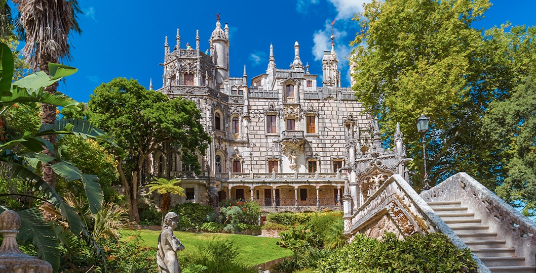 Quinta da Regaleira palace with ornate facade and lush gardens in Sintra, Portugal.