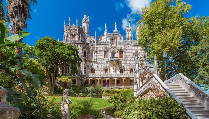 Quinta da Regaleira palace with ornate facade and lush gardens in Sintra, Portugal.