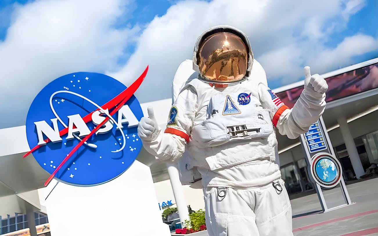 Staff member in spacesuit outside Houston Space Center entrance.