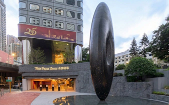 Entrance to The Peak Tram station in Hong Kong with modern sculpture.