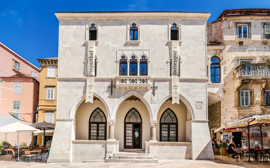 Old Town Hall in Narodni Trg, Split, Croatia, featuring Gothic arches and historic architecture.