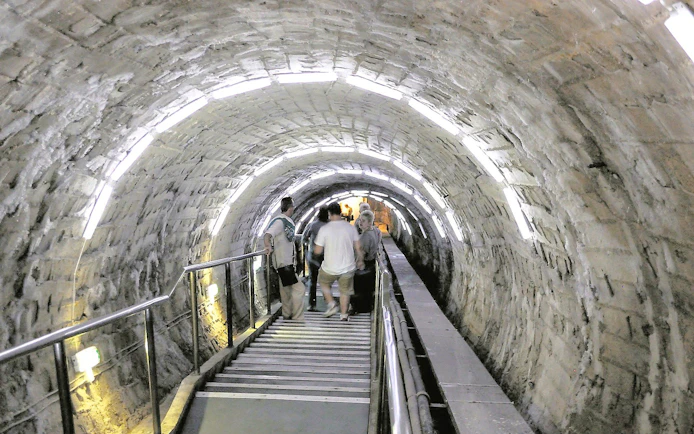 Guests walking through illuminated tunnel inside Slanic Salt Mine.