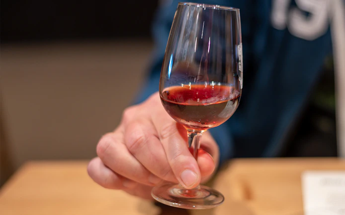 Port wine glass held during tasting session.