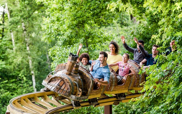 Visitors on a roller coaster at Astérix Park, France, enjoying a thrilling ride.