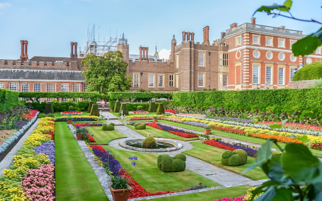Visitors exploring 20th century gardens at Hampton Court Palace on a sunny day.
