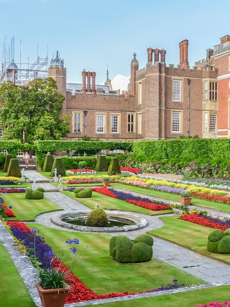 Visitors exploring 20th century gardens at Hampton Court Palace on a sunny day.