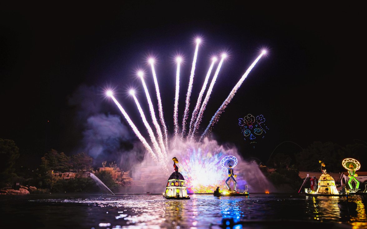 Nighttime FiestAventura show with fireworks over the lake in PortAventura, Spain.