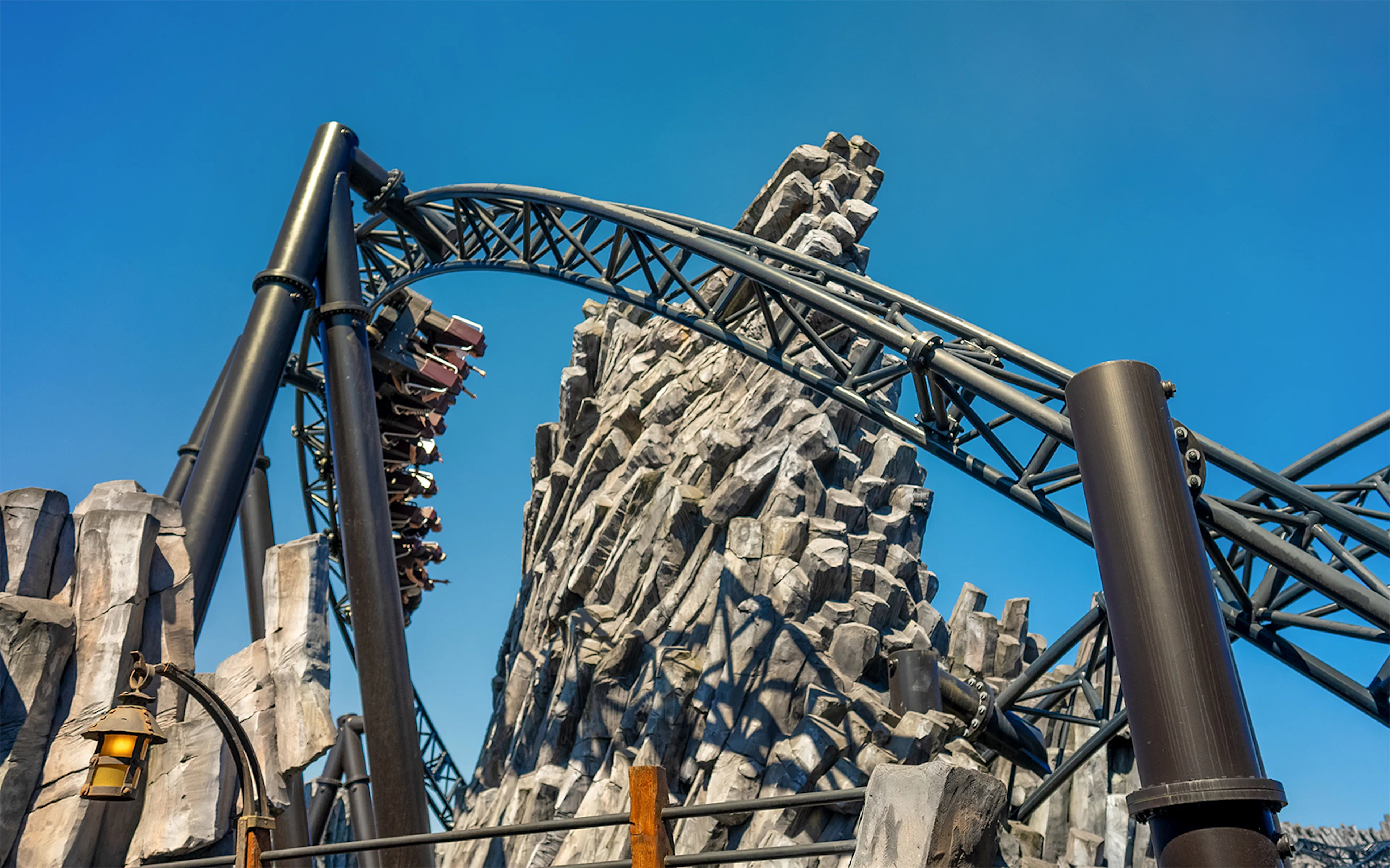 Taron launch coaster track in Mystery theme park, Phantasialand, with rocky backdrop.