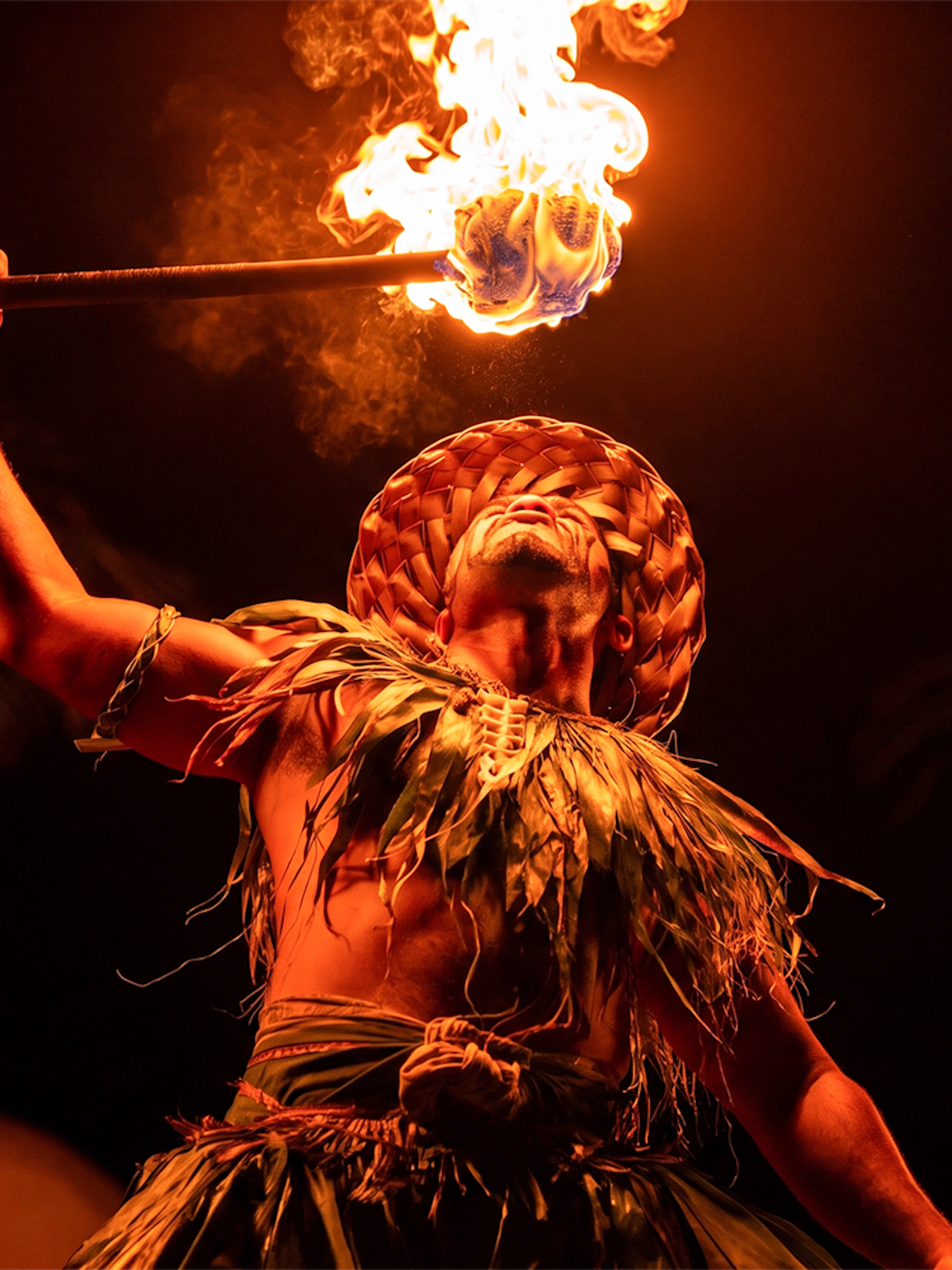 Performer holding a flaming torch at Mauka Warriors Luau.