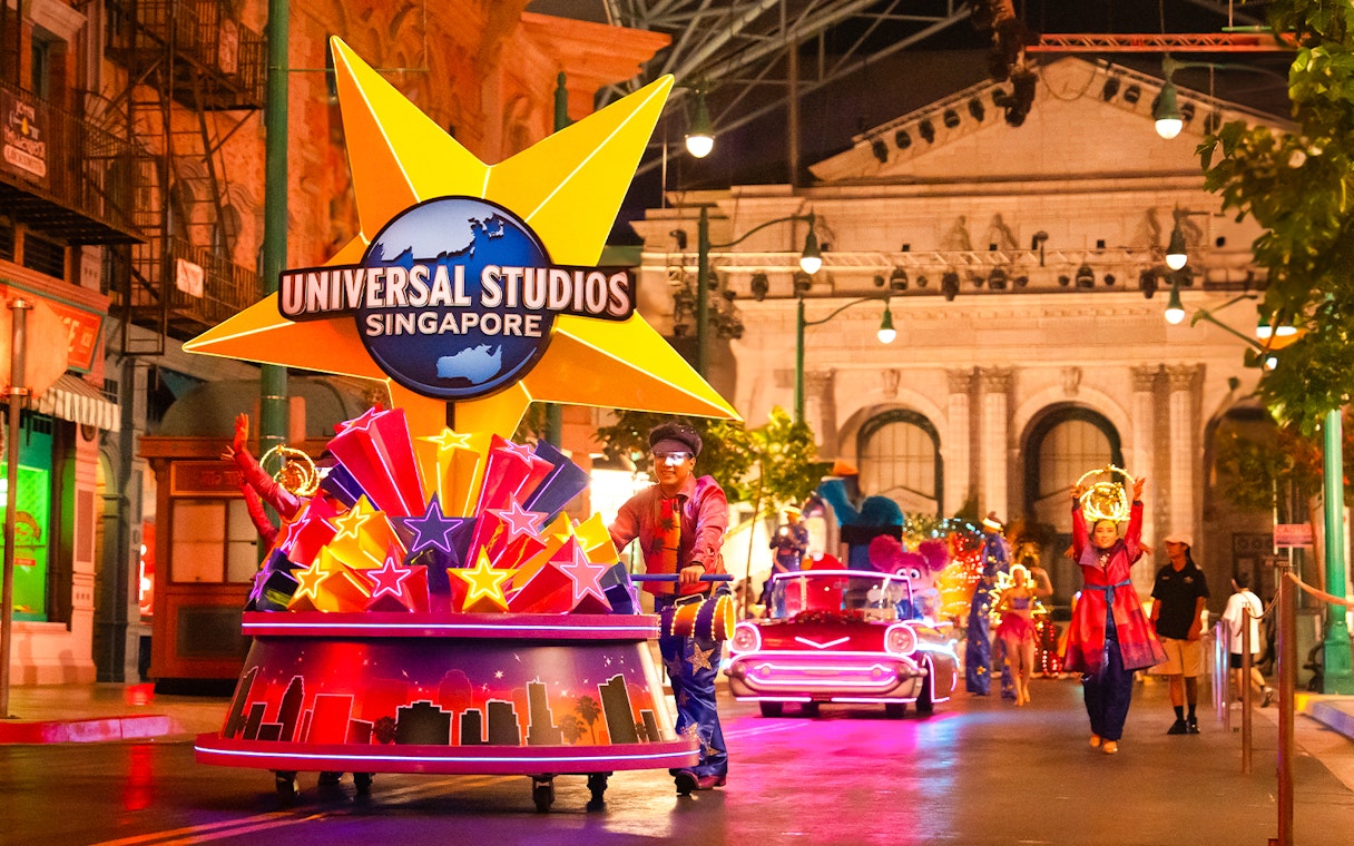 Universal Studios Singapore parade with performers and illuminated floats.