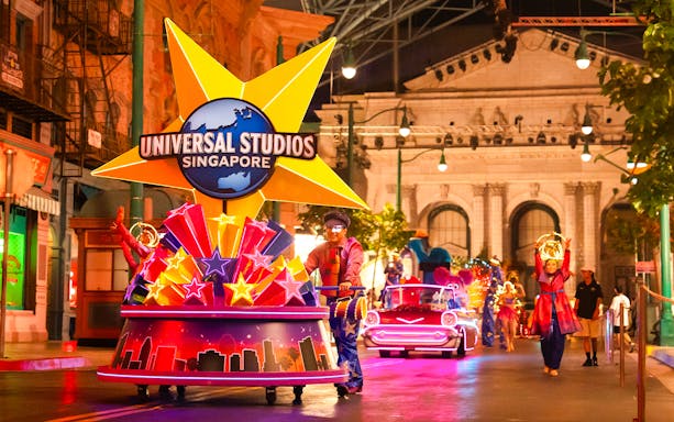 Universal Studios Singapore parade with performers and illuminated floats.