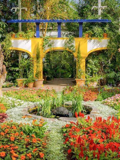 Colorful flower garden with archway inside New York Botanical Garden.