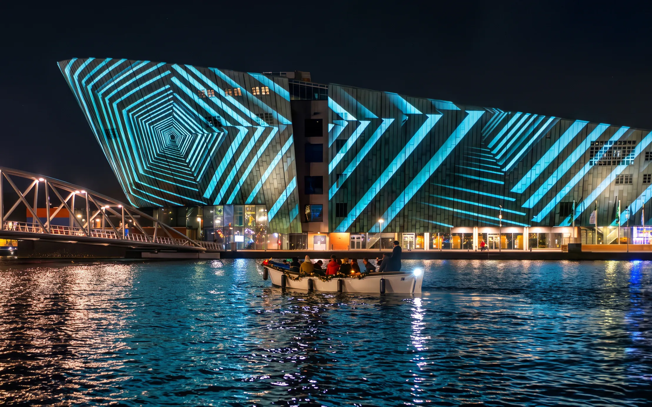 Boat tour at Amsterdam Light Festival with illuminated geometric patterns on a building.