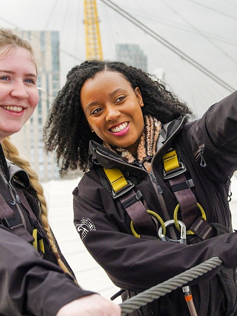 Guide pointing while talking to tourist on rooftop tour in London.