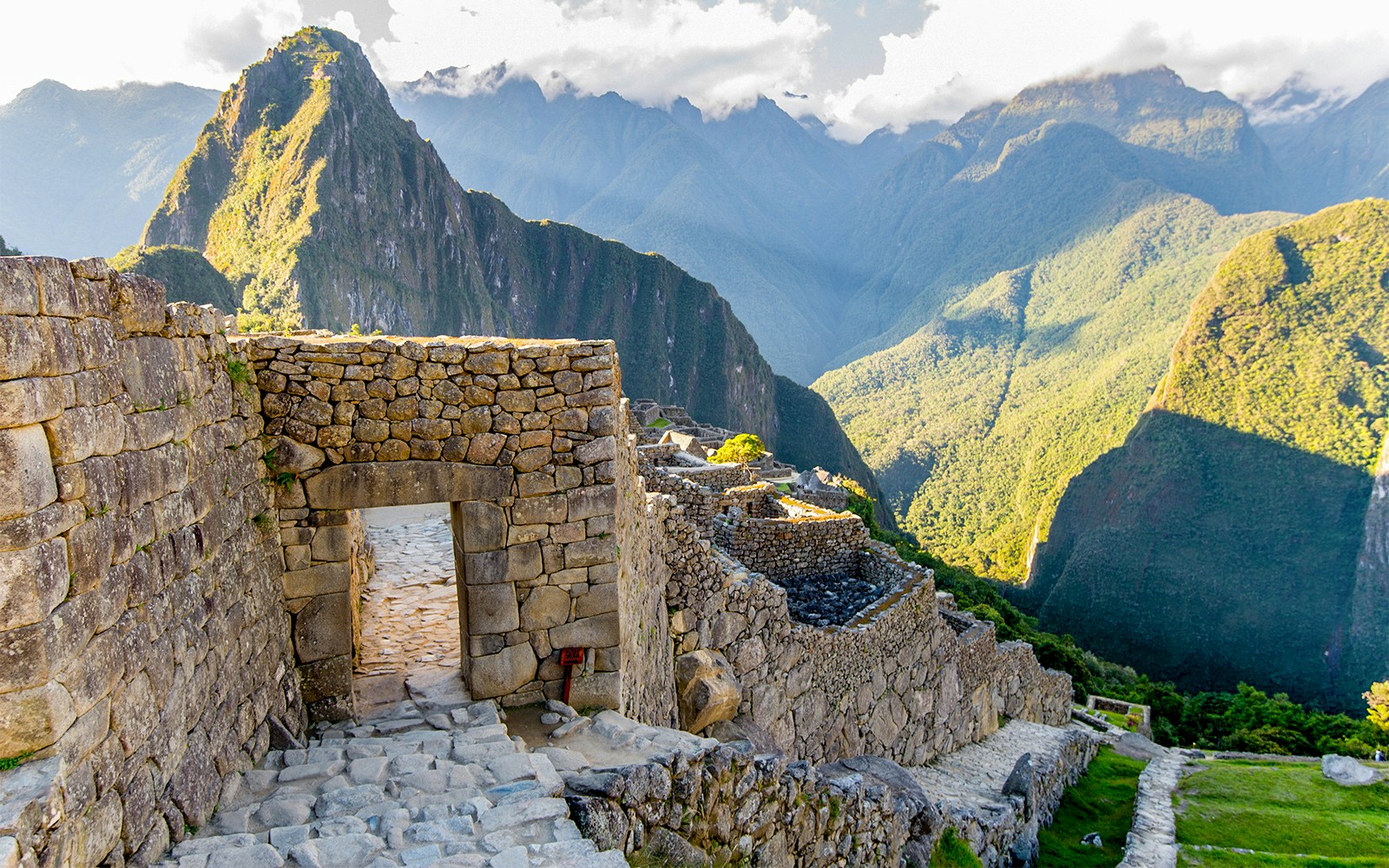 Inca Gate at Machu Picchu with stone structures and mountain backdrop.