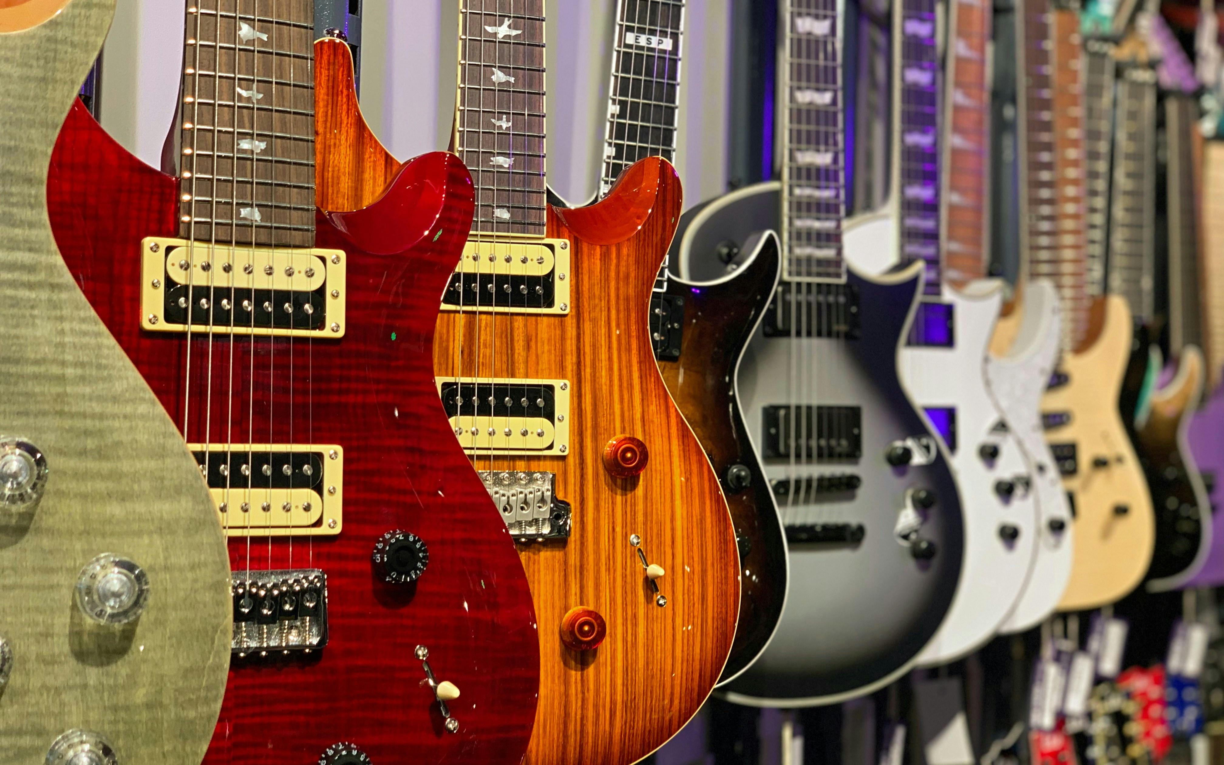 Row of electric guitars on display at a guitar museum.
