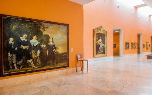 Thyssen Museum gallery with classic art paintings on orange walls.