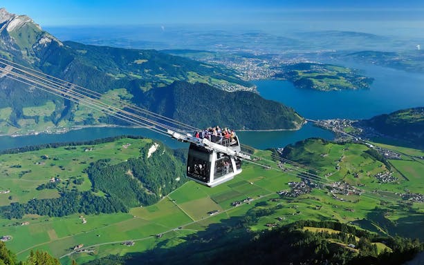 Cable car ascending Mount Stanserhorn with views of Lake Lucerne, Switzerland.