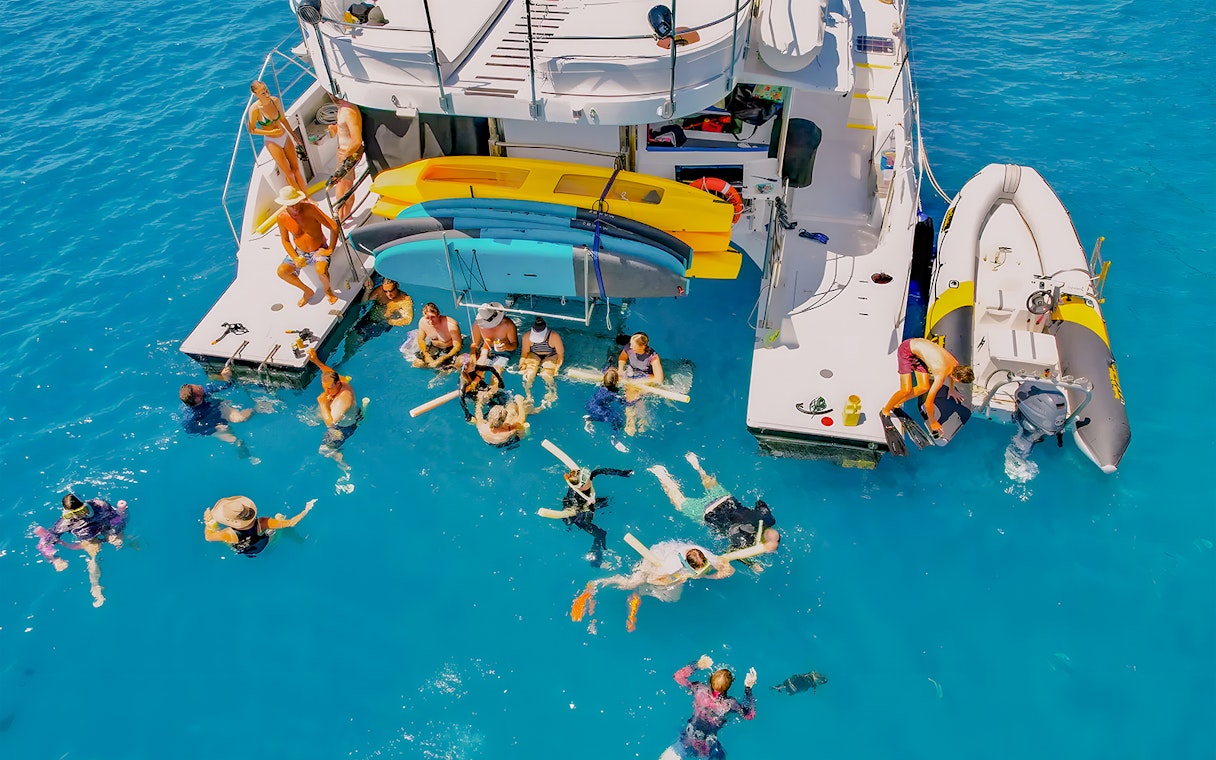 Tourists swimming near a chartered catamaran in the Whitsundays.