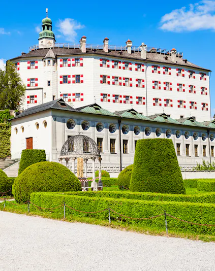 Ambras Castle in Innsbruck with manicured gardens and historic architecture.