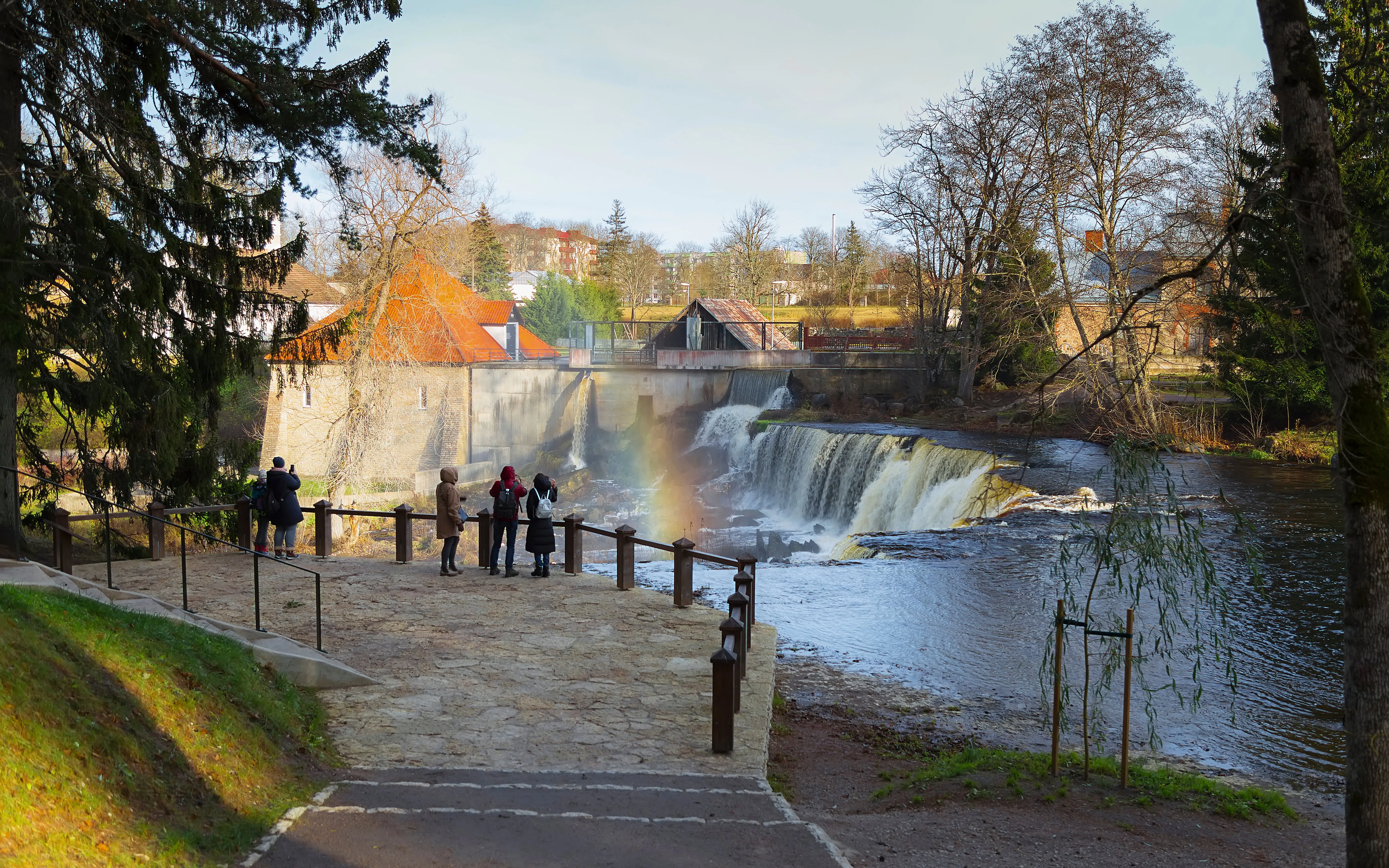 Visitors viewing Keila Waterfall with rainbow in Northern Estonia.