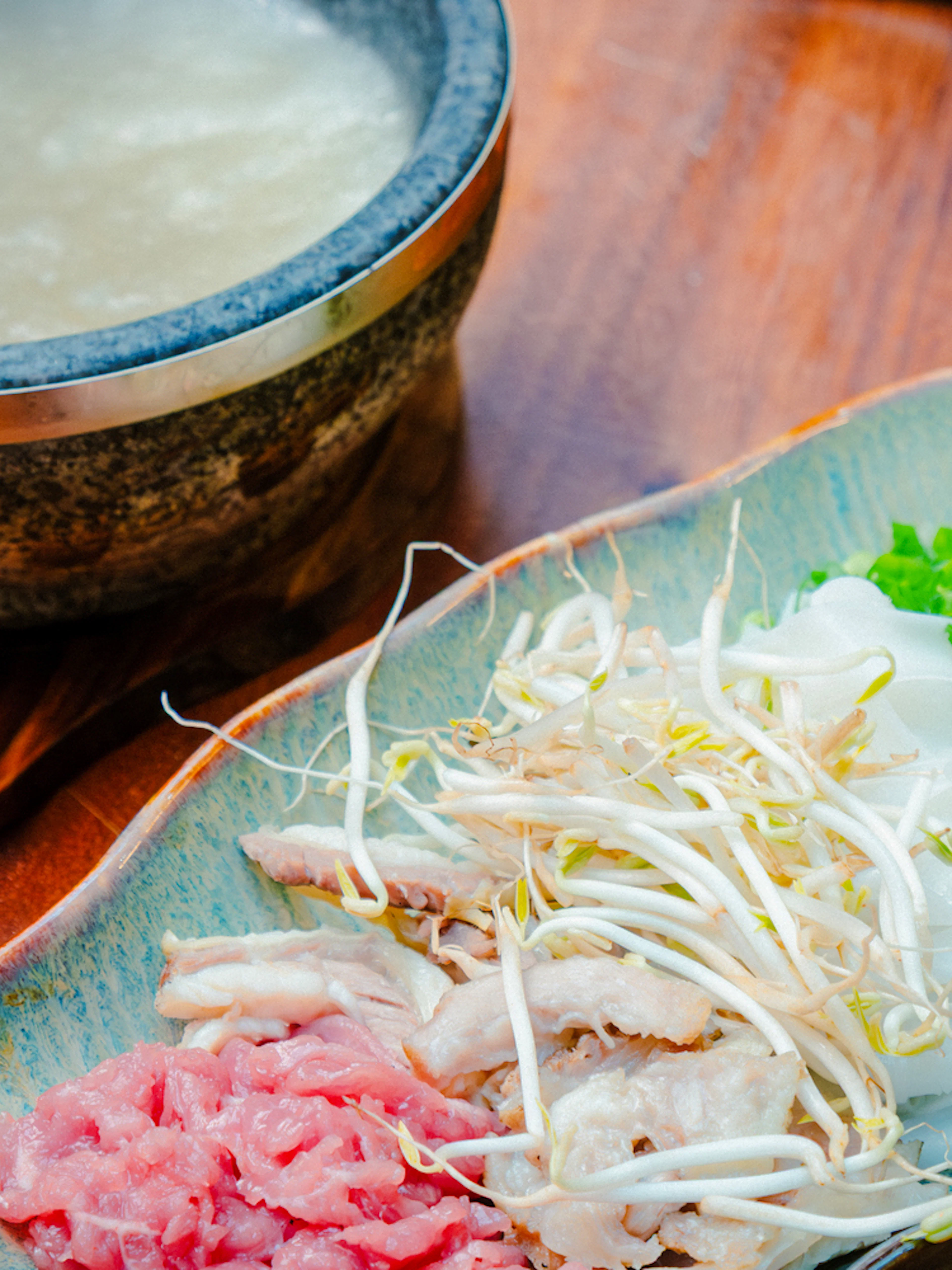 Stone bowl with pho ingredients and broth for cooking class in Hanoi.