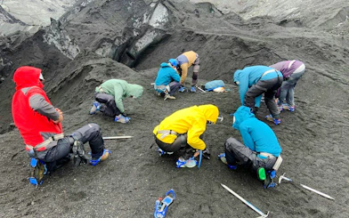Guests preparing gear on Sólheimajökull Glacier during small group hiking tour.