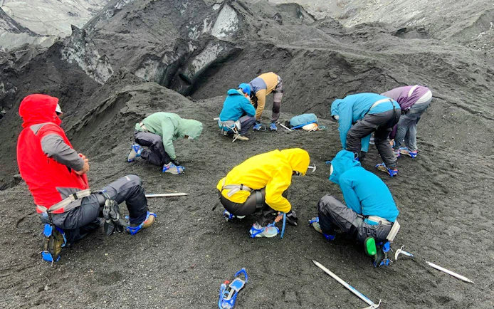 Guests preparing gear on Sólheimajökull Glacier during small group hiking tour.