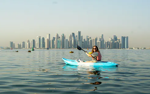 Kayaker on The Pearl Guided Kayak Tour in Doha with city skyline in background.