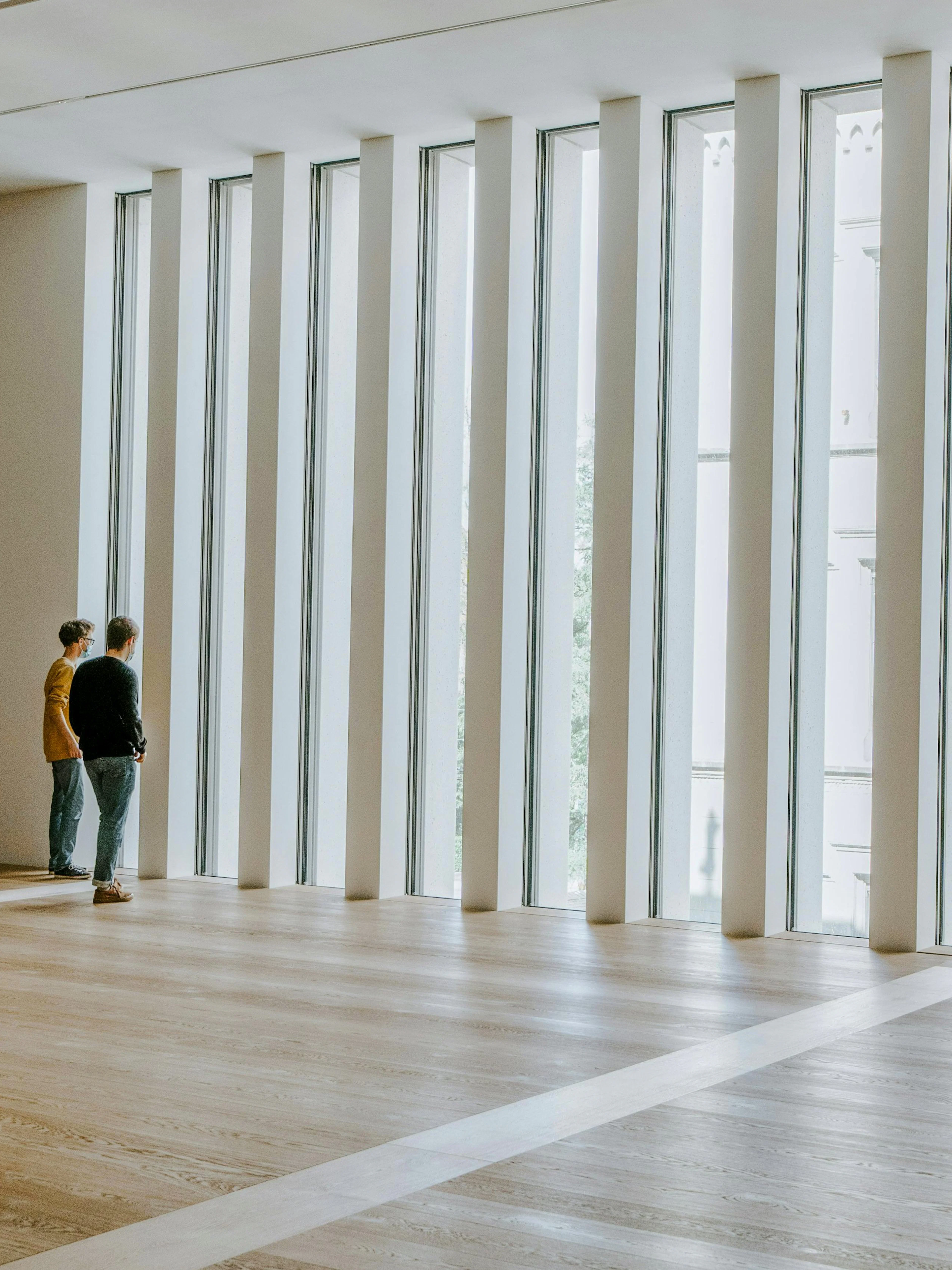 Visitors observing large windows inside Kunsthaus Zürich.
