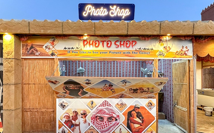 Photo shop booth for desert safari experience with camel ride images.