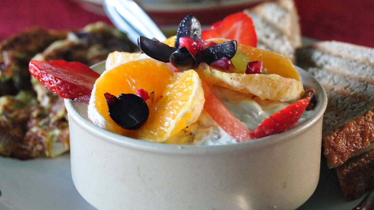 Dining tables set in a vibrant restaurant with patrons enjoying meals.