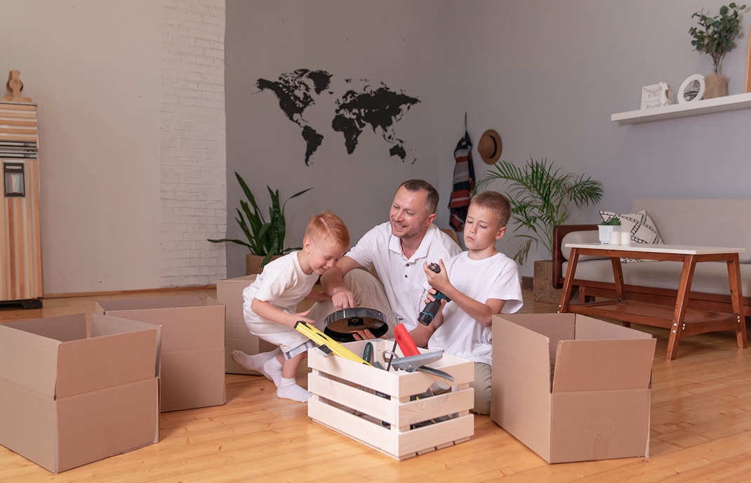 Father playing with his sons in a timber floored lodge
