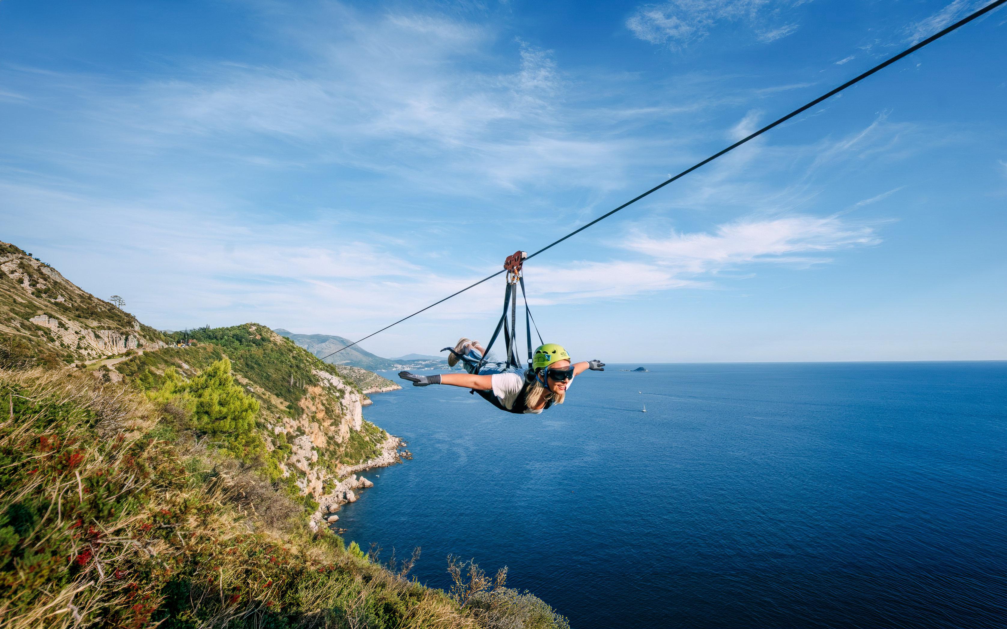 Zip lining over Pasjača Beach, Croatia with coastal views.