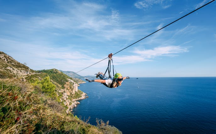 Zip lining over Pasjača Beach, Croatia with coastal views.