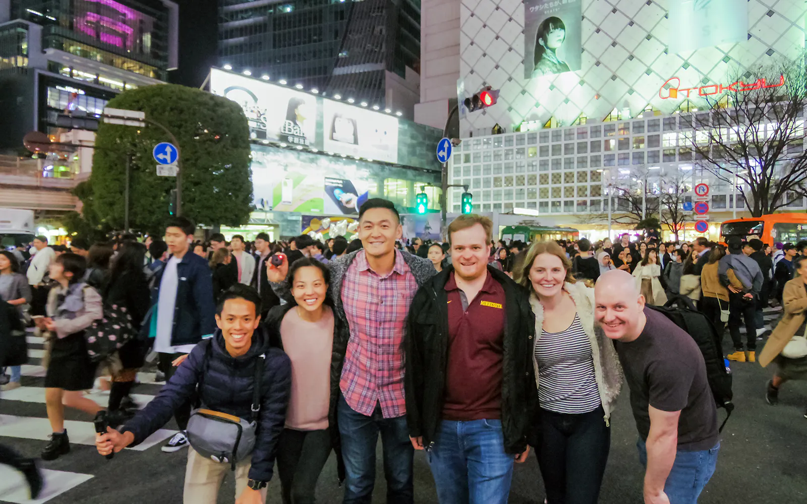 Tourists at Shibuya Crossing, Tokyo, exploring local izakaya bars and Japanese cuisine.