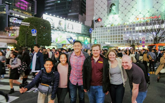 Tourists at Shibuya Crossing, Tokyo, exploring local izakaya bars and Japanese cuisine.